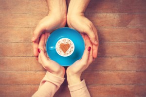Women and man holding cup of coffee